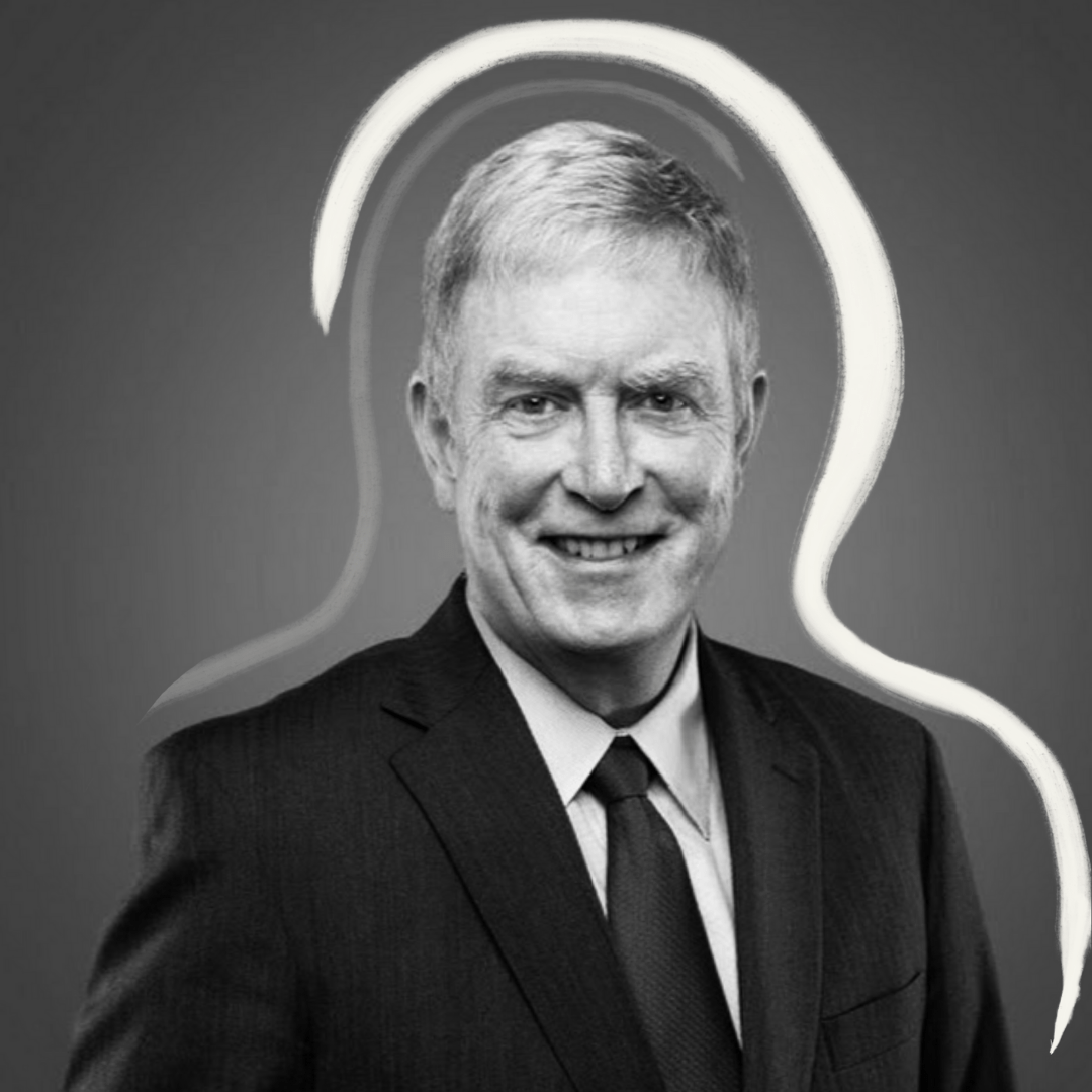 A man in a suit and tie smiles at the camera against a gray background, with a white, abstract outline drawn around his head and shoulders.