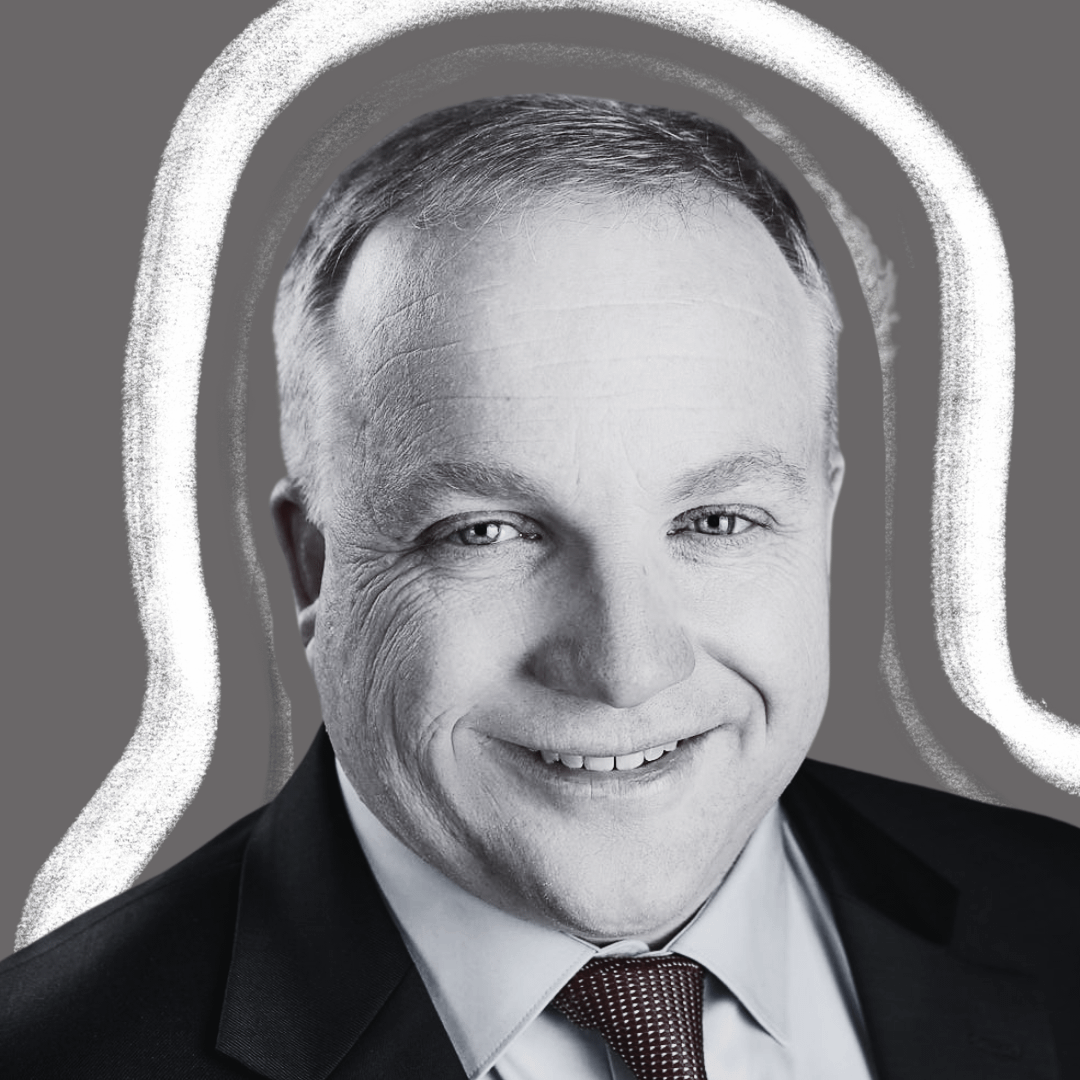 A middle-aged man in a suit and tie smiles at the camera; the grayscale image features a bold, white, hand-drawn outline around his head against a gray background.